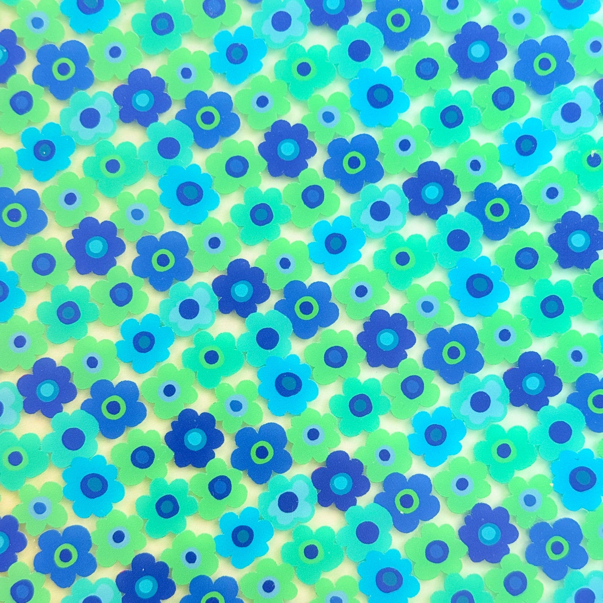 The image is a vibrant and colorful collage of various blue and green flowers, creating a lively and cheerful visual effect.