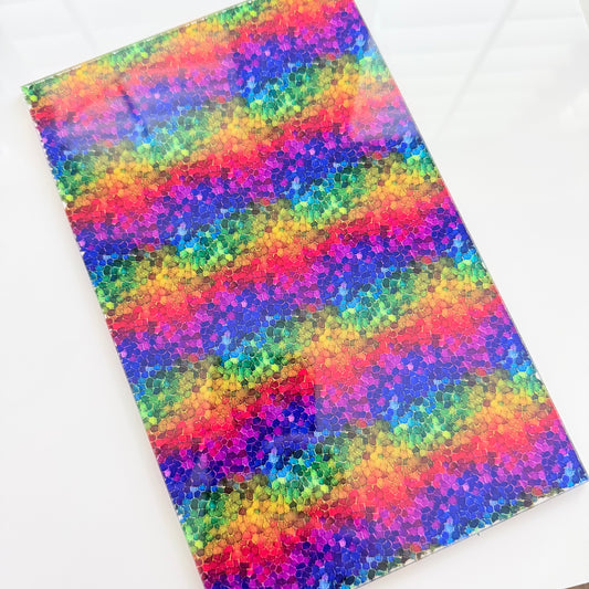 a vibrant, colorful pattern with a mosaic-like design, consisting of various shades of red, orange, yellow, green, blue, and purple. The pattern appears to be a digital artwork or a printed design, with the colors and shapes creating a visually striking and lively composition.