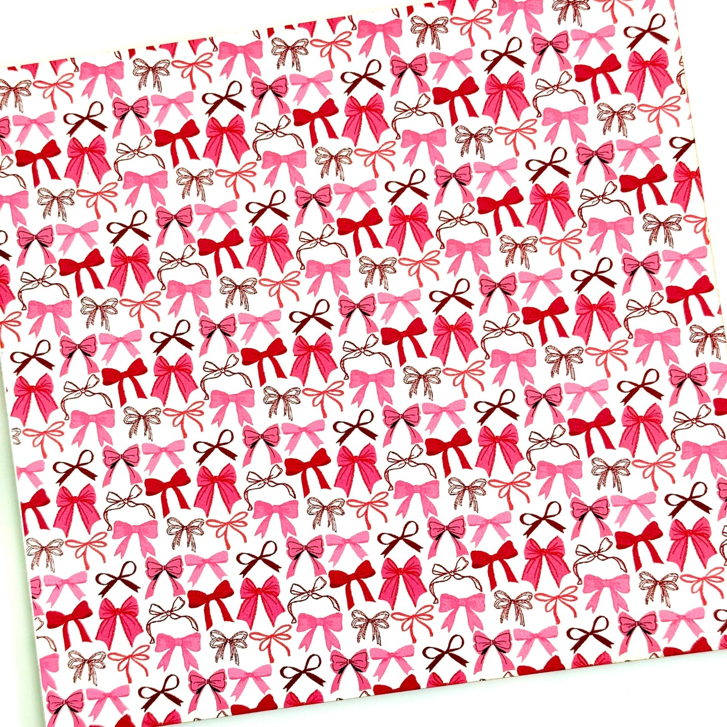 a repeating pattern of pink and brown bows on a white background.