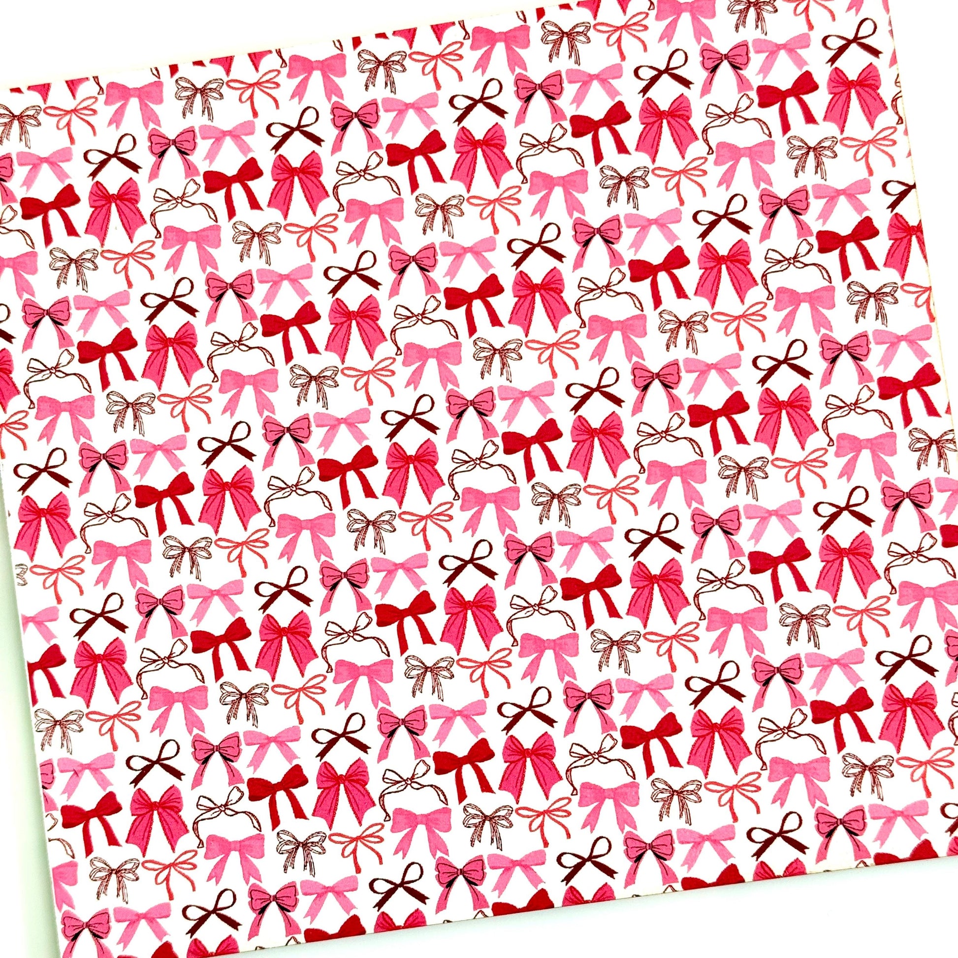 a repeating pattern of pink and brown bows on a white background.