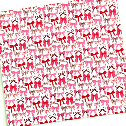 a repeating pattern of pink and brown bows on a white background.