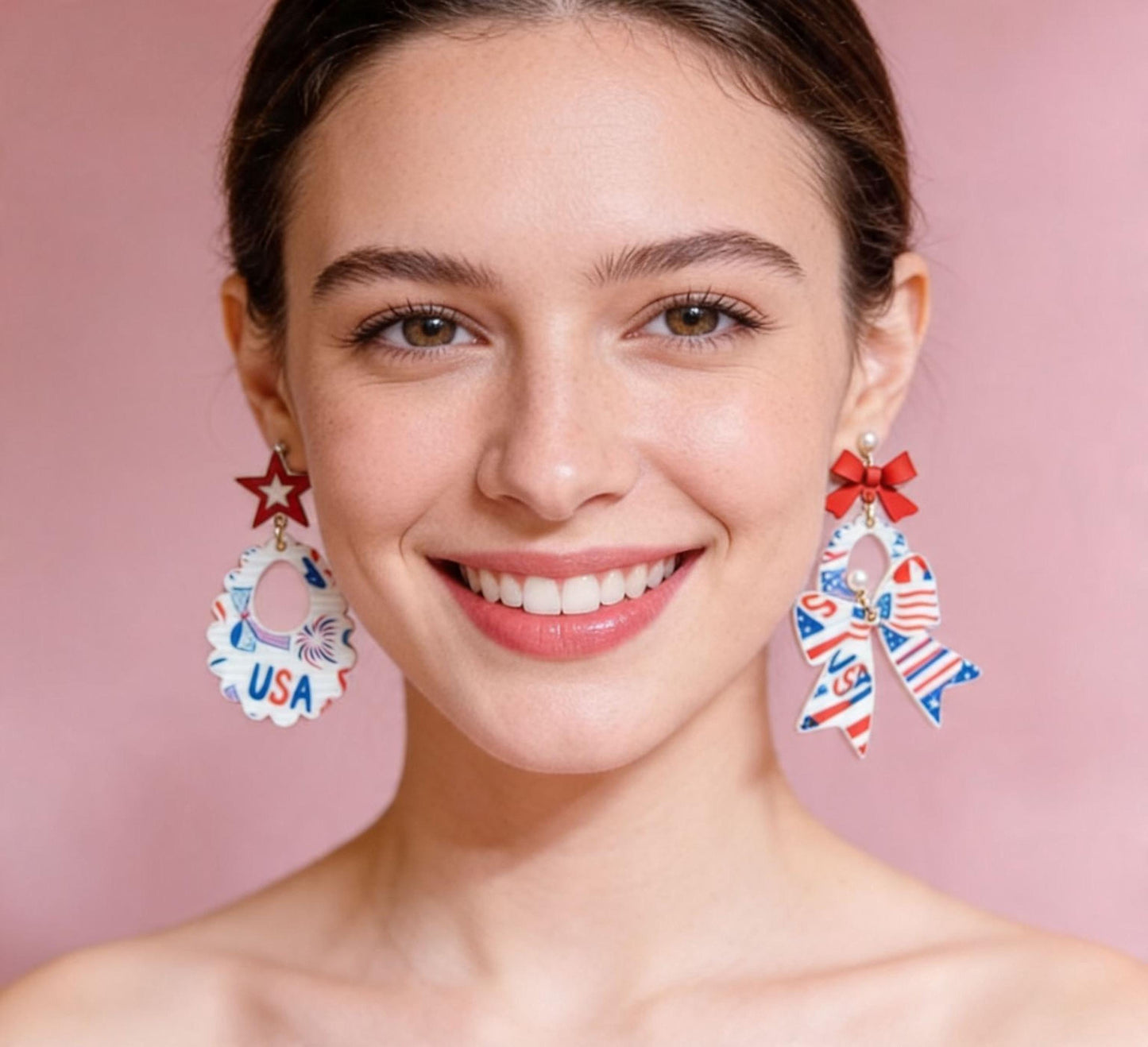 A woman with a bright smile, wearing large earrings with patriotic designs, including stars and stripes, against a pink background.