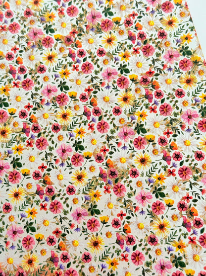 The image is a vibrant and colorful collage of various flowers and leaves, creating a lively and visually appealing pattern.