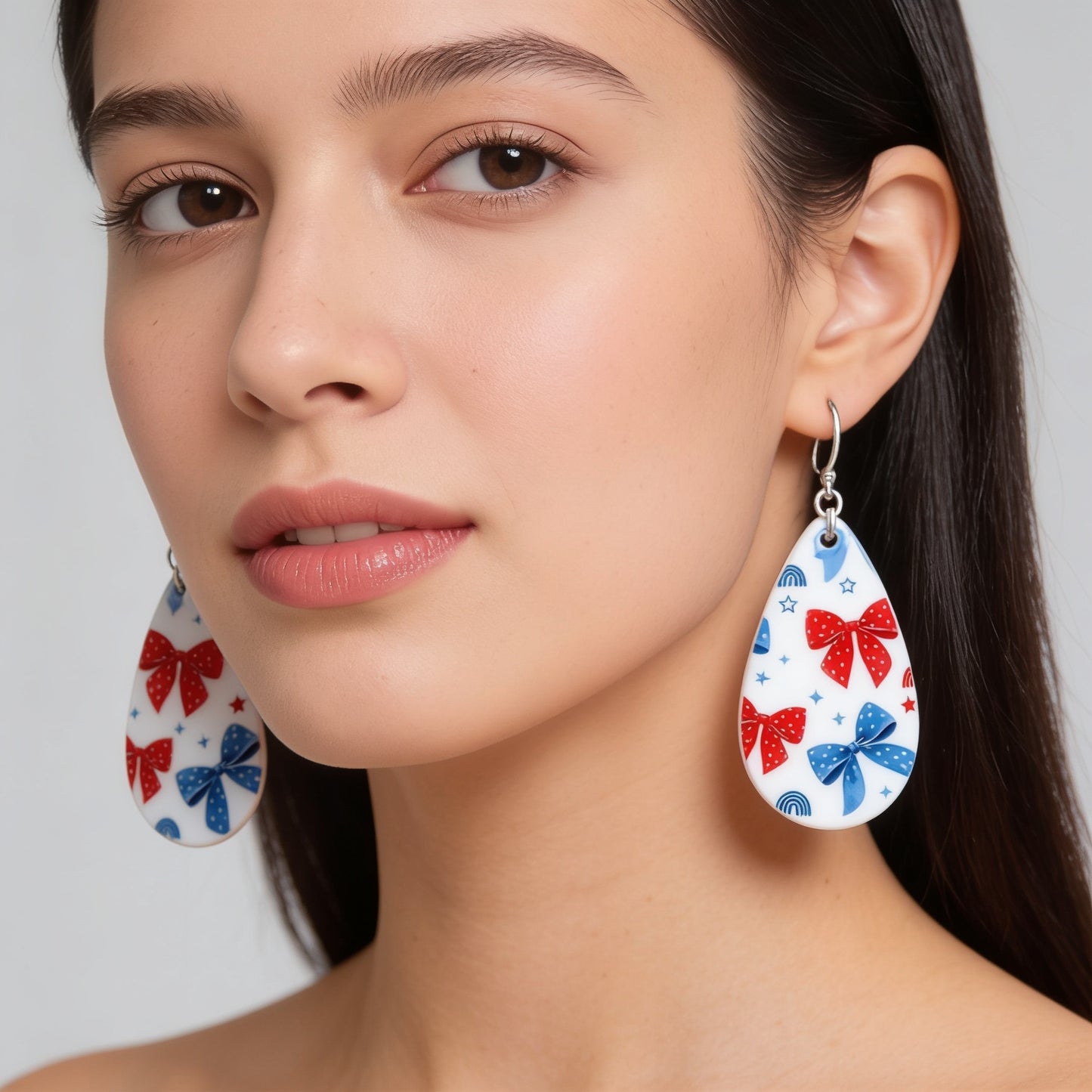 A close-up portrait of a woman wearing large earrings with a bow design.