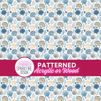 a repeating pattern of seashells and leaves in shades of blue, brown, and green. The pattern is displayed on a white background, and there is a pink banner with the text "PATTERNED Acrylic or Wood" in the center.