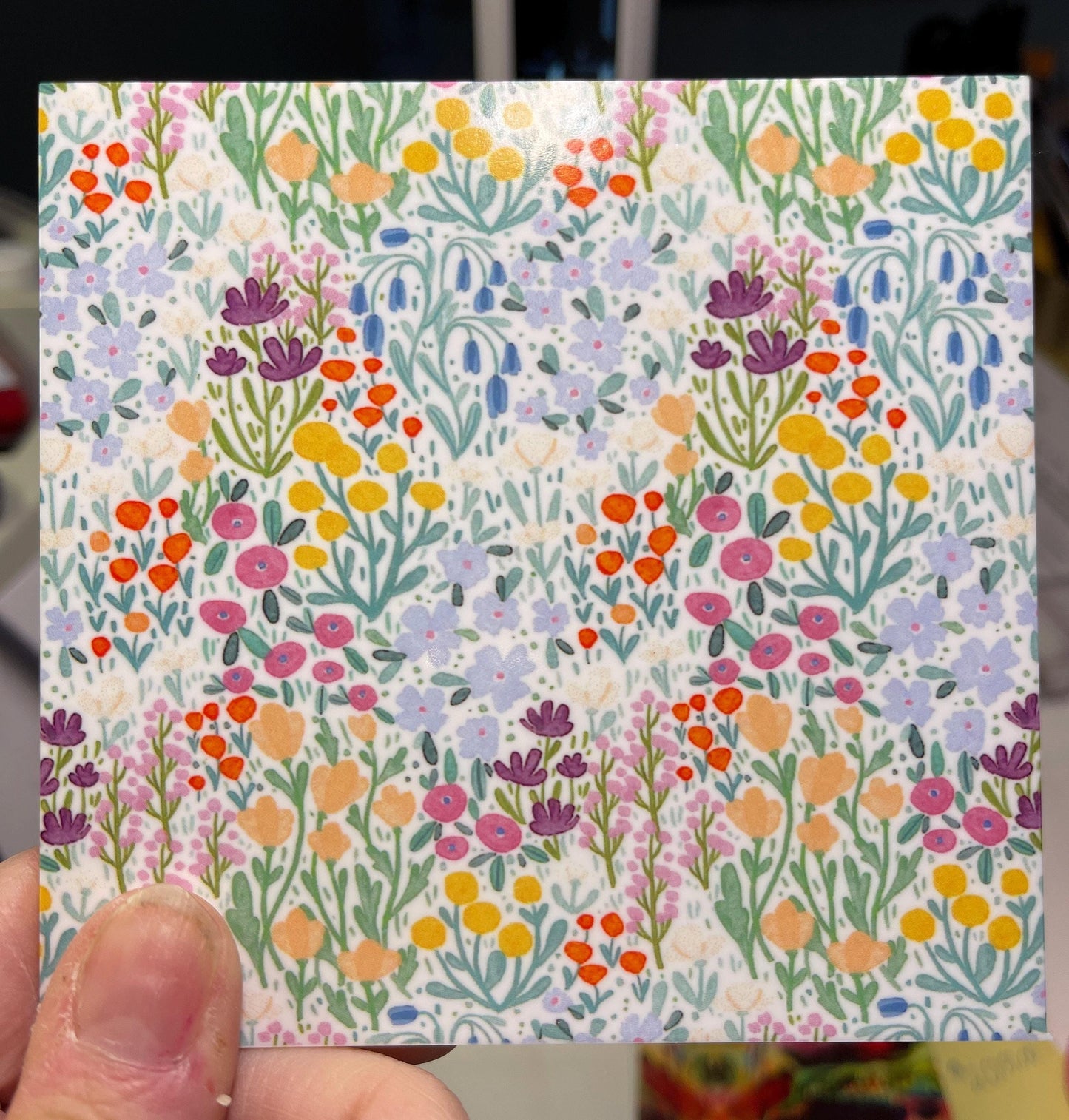 a person holding up a card with flowers on it